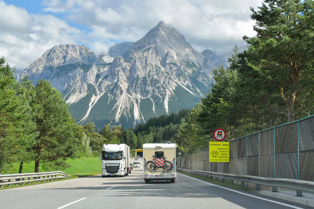 Eine befahrene Straße mit der Bergspitze Serles im Hintergrund